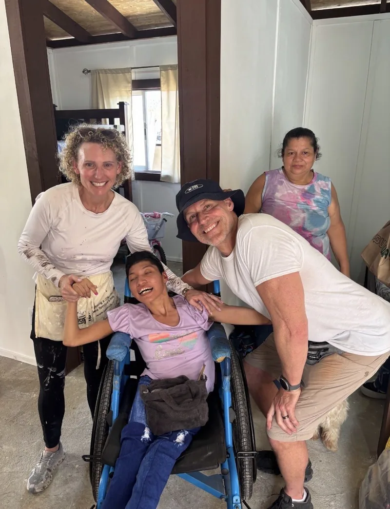 Todd and a volunteer visiting with a family inside their newly completed home.