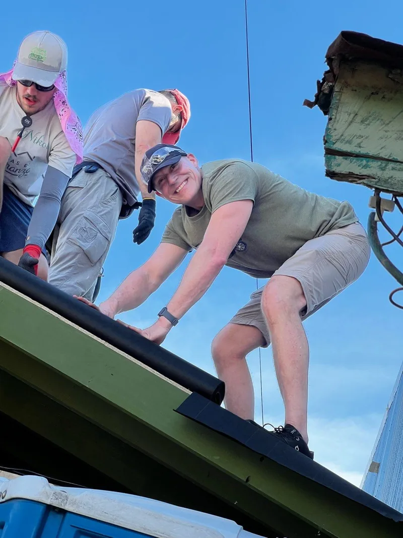 Todd Jones helping put a roof on a new home on a build trip.